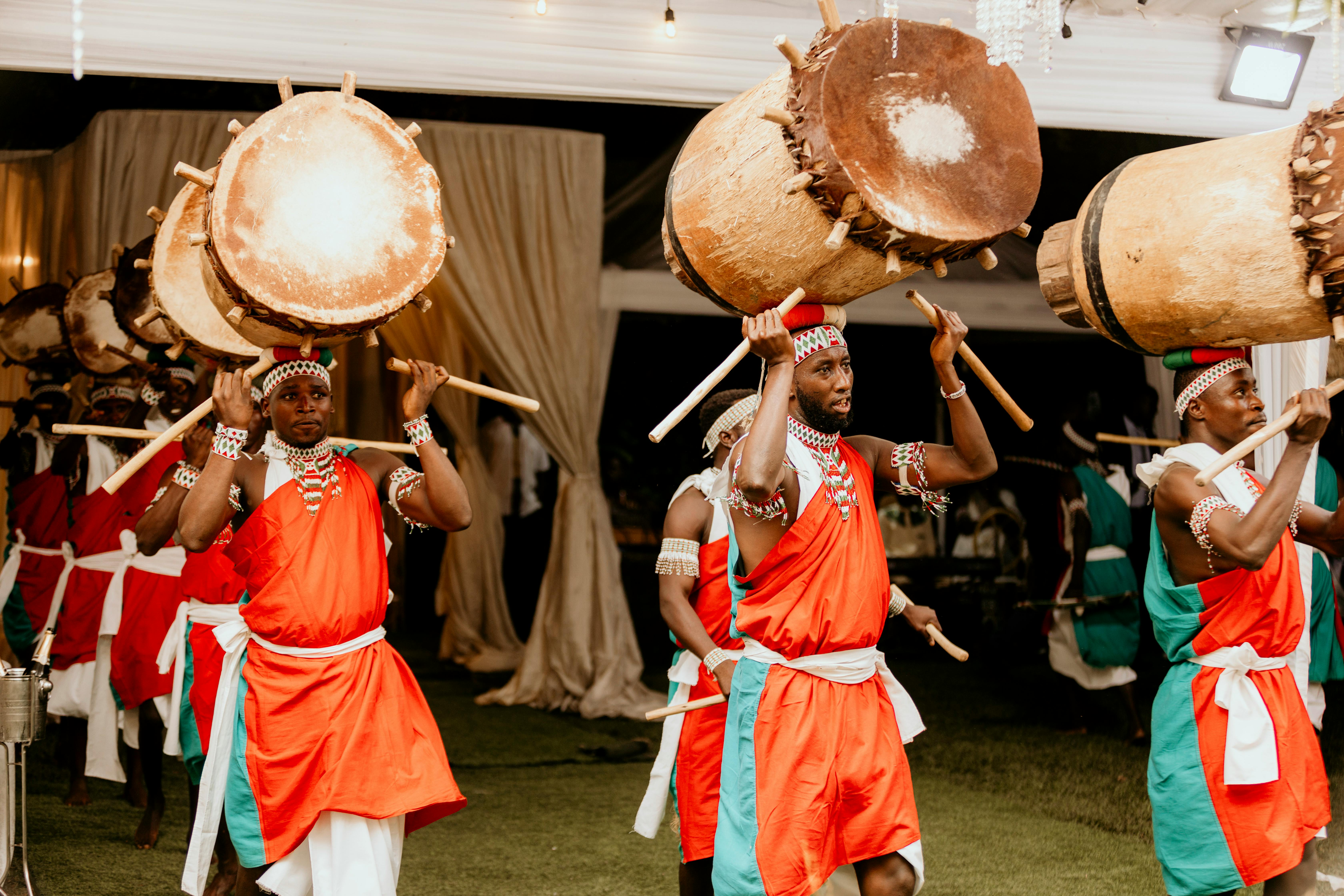 Vibrant African drummers in traditional attire performing at a cultural festival indoors